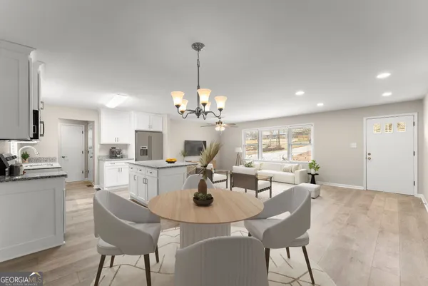 a view of a dining room and a kitchen with a chandelier