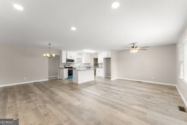 a view of kitchen with kitchen island stainless steel appliances cabinets and wooden floor