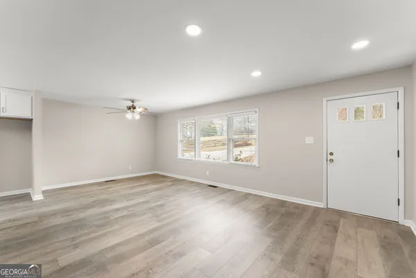 an empty room with wooden floor and windows