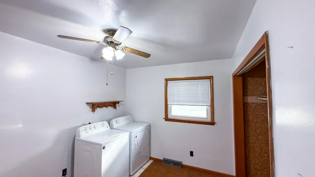 a bathroom with a sink a window and a fan