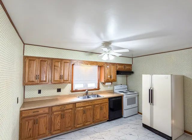 a kitchen with refrigerator cabinets and window