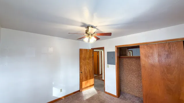 a view of hallway with chandelier fan and a window