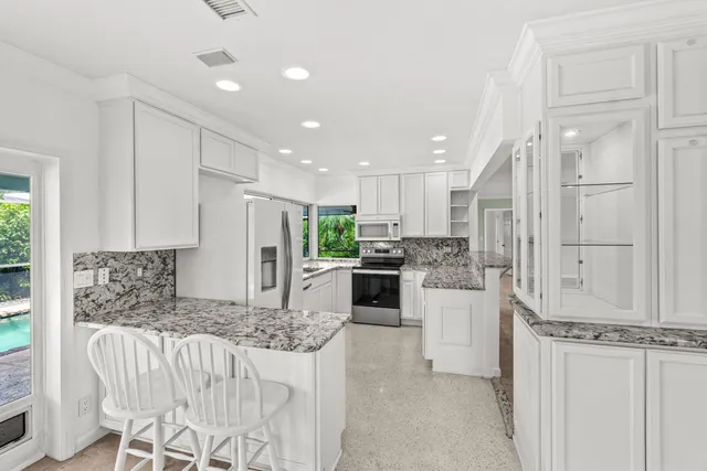 a kitchen with white cabinets and stainless steel appliances