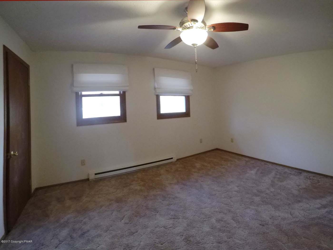 50 Dancing Ridge Road East Stroudsburg, PA 18302 - Photo 20 of 25 an empty room with a chandelier fan and windows