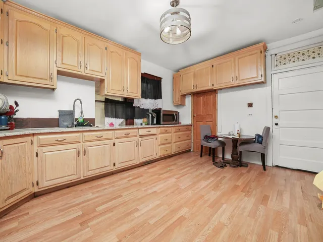 a kitchen with a sink cabinets and wooden floor
