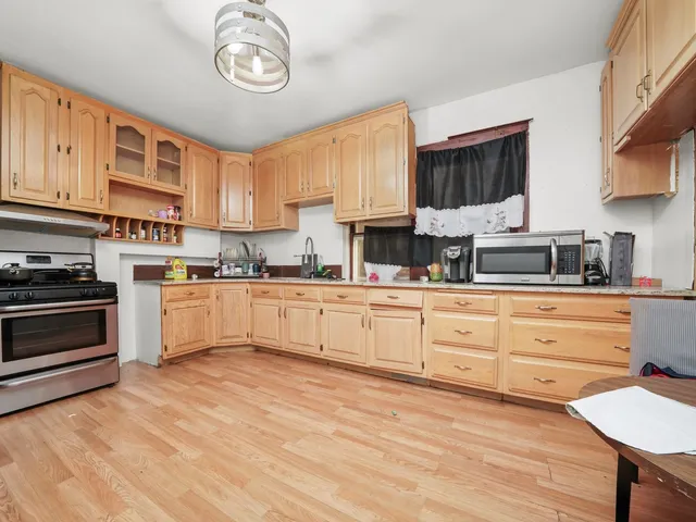 a kitchen with stainless steel appliances granite countertop a stove sink and cabinets