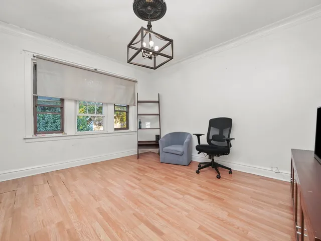 a view of a workspace with furniture and a window