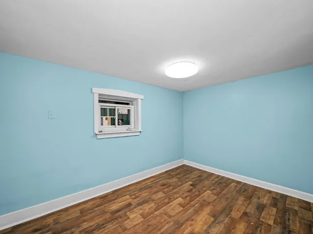 a view of a room with wooden floor and white walls
