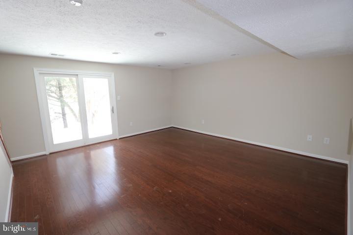 10149 Shelldrake Circle Damascus, MD 20872 - Photo 10 of 28 a view of an empty room with wooden floor and a window