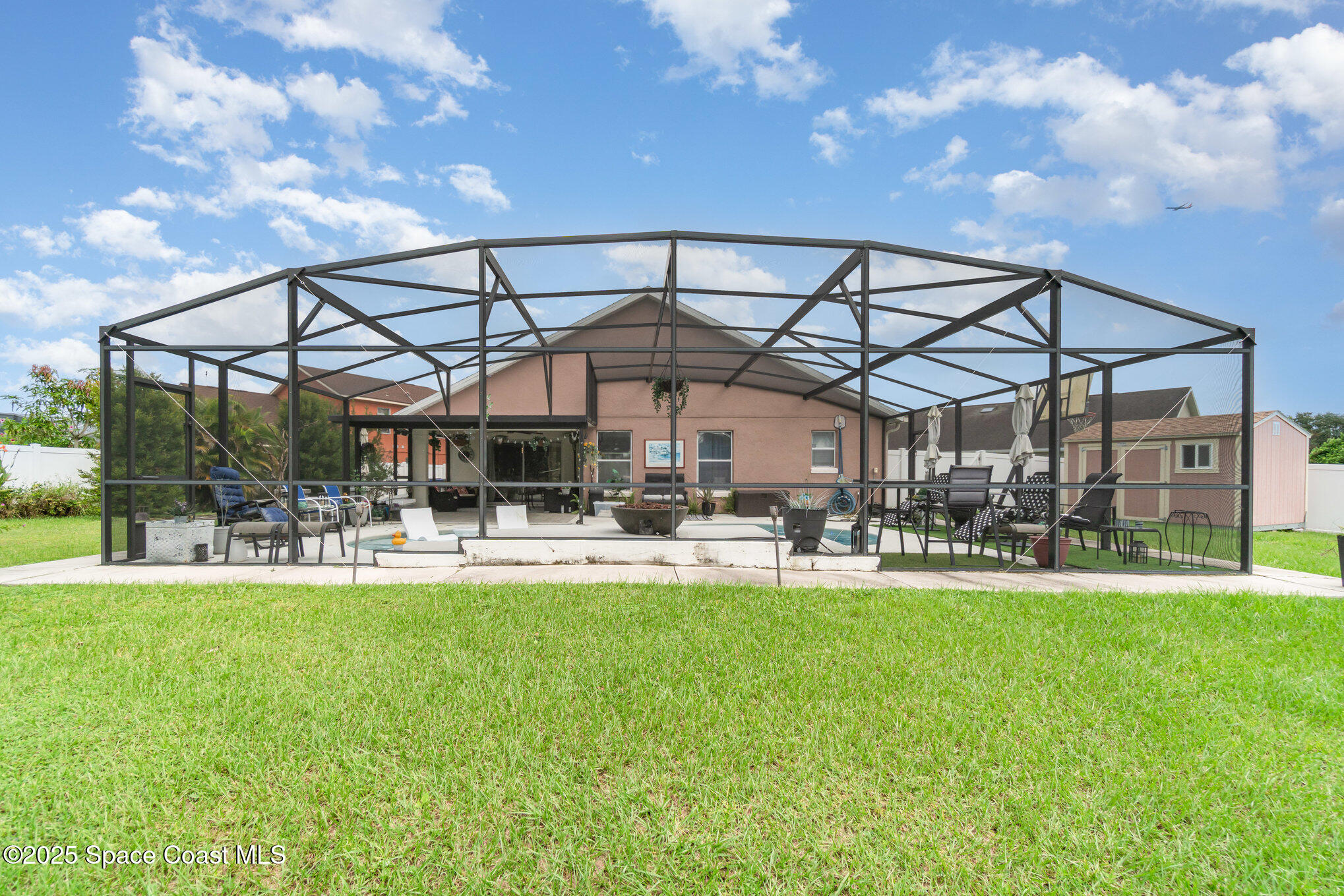 1350 Creekview Court St. Cloud, FL 34772 - Photo 26 of 27 a patio with a table and chairs and a umbrella