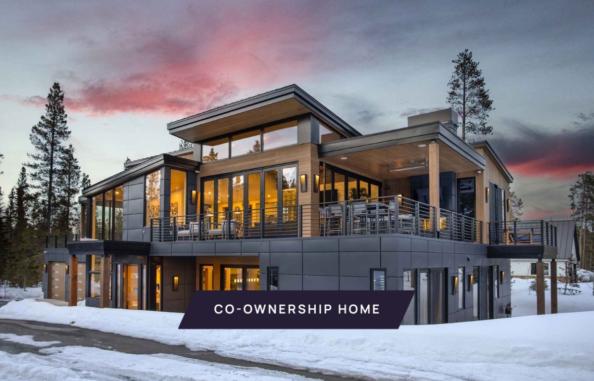 Snow covered back of property featuring a balcony