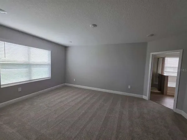 an empty room with windows and closet