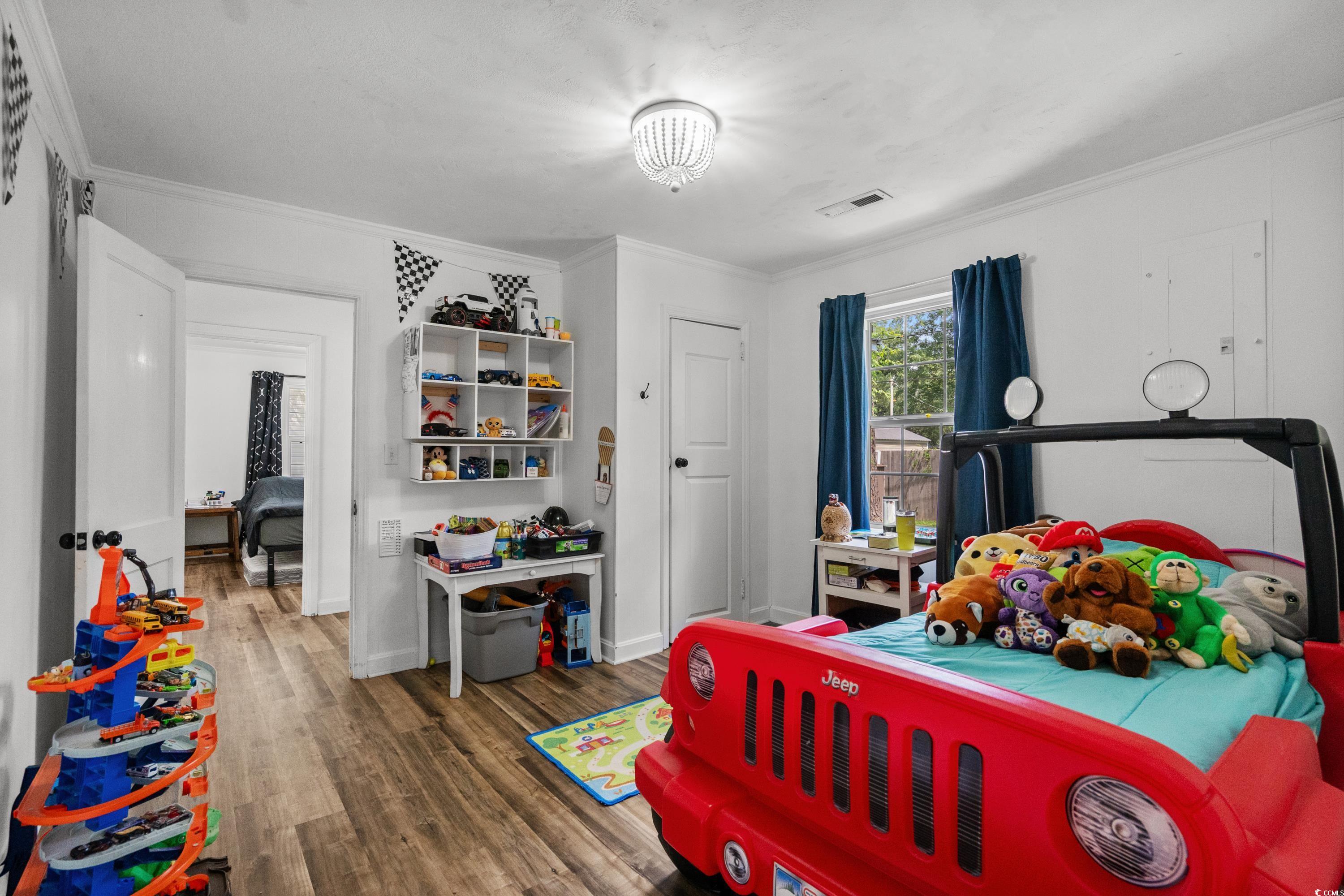 708 15th Avenue Conway, SC 29526 - Photo 13 of 38 Bedroom with stainless steel fridge with ice dispenser, crown molding, and wood finished floors