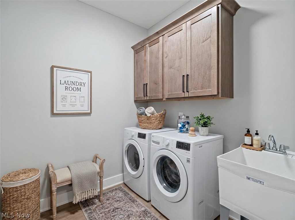 32 Brookside Lane North Ridgeville, OH 44039 - Photo 10 of 50 Laundry room featuring cabinet space, washing machine and dryer, and light wood-type flooring