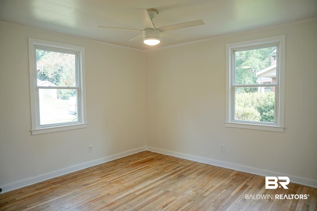 4667 Cottonwood Drive Mobile, AL 36608 - Photo 18 of 21 Unfurnished room featuring ceiling fan, a healthy amount of sunlight, light hardwood / wood-style floors, and ornamental molding