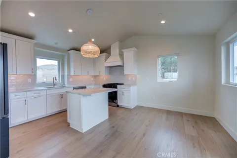a view of a hallway with bathroom and wooden floor