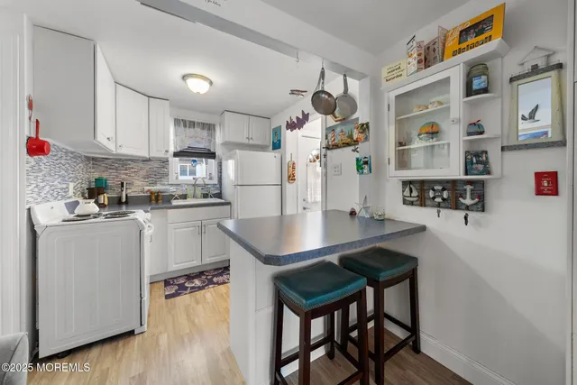 a kitchen with stainless steel appliances granite countertop a table chairs sink and cabinets