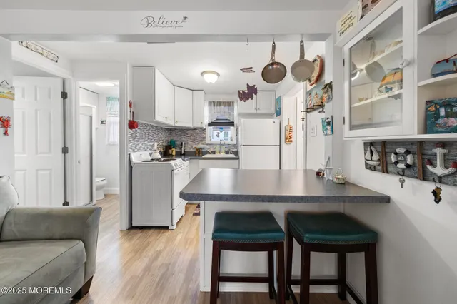 a kitchen with kitchen island a stove cabinets and wooden floor