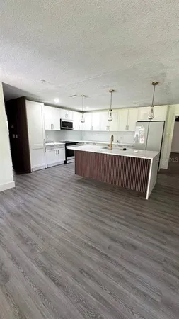 a kitchen with stainless steel appliances wooden floor and a view of kitchen