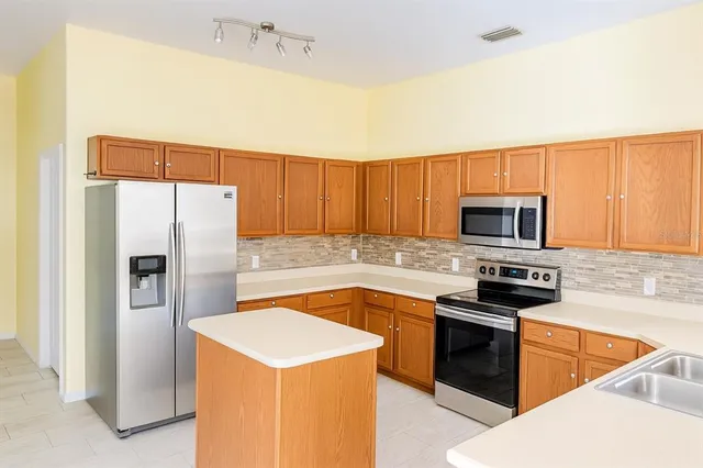 a kitchen with stainless steel appliances granite countertop a refrigerator stove and microwave