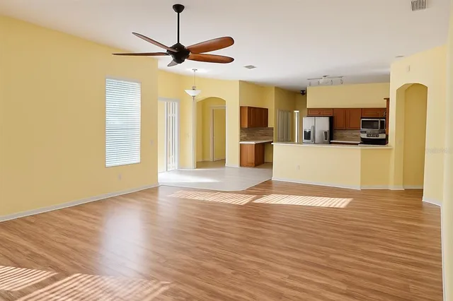 a view of a kitchen with wooden floor and a ceiling fan
