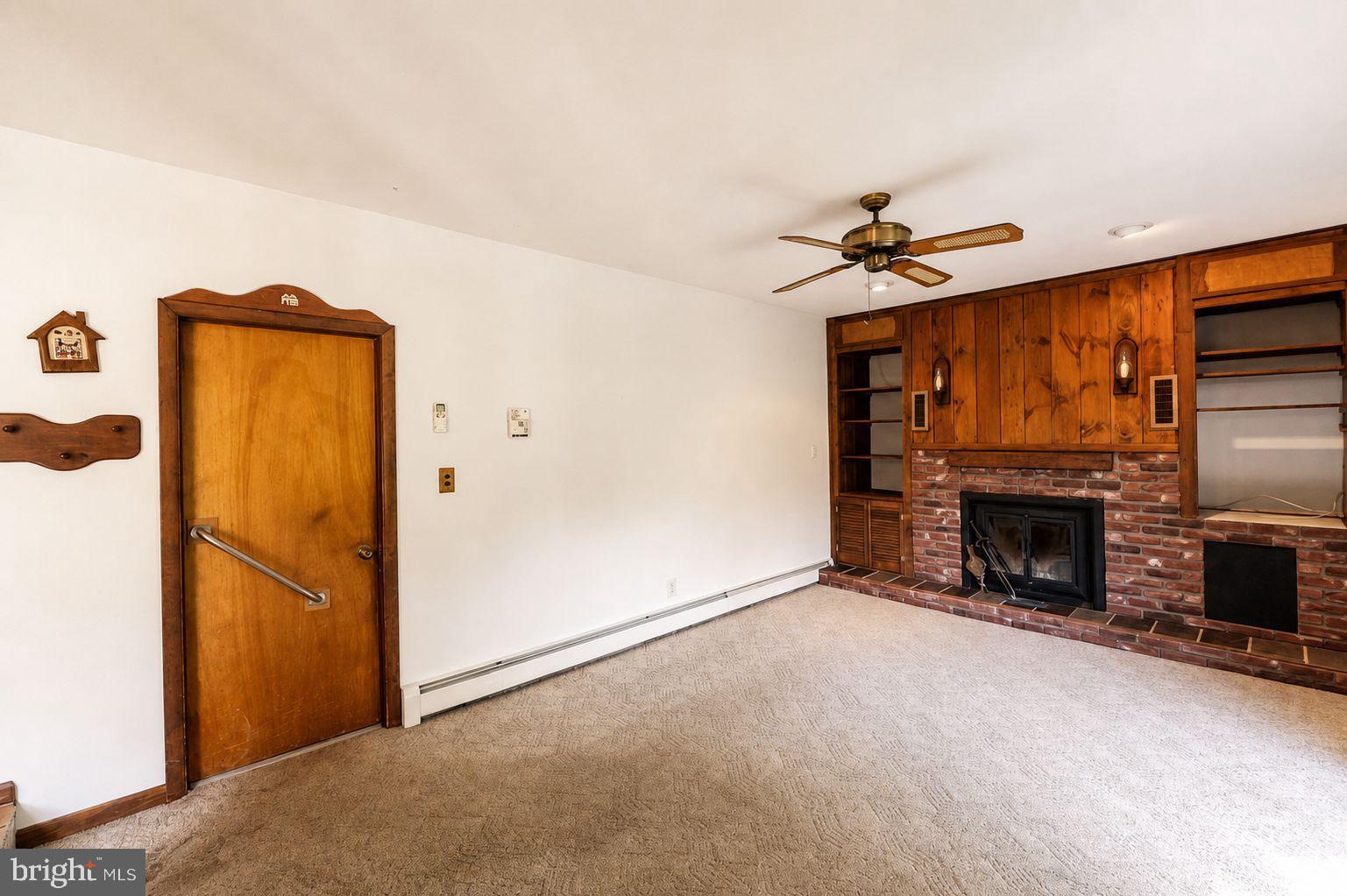 223 Trythall Road Elverson, PA 19520 - Photo 30 of 78 an empty room with fireplace cabinet and a flat screen tv
