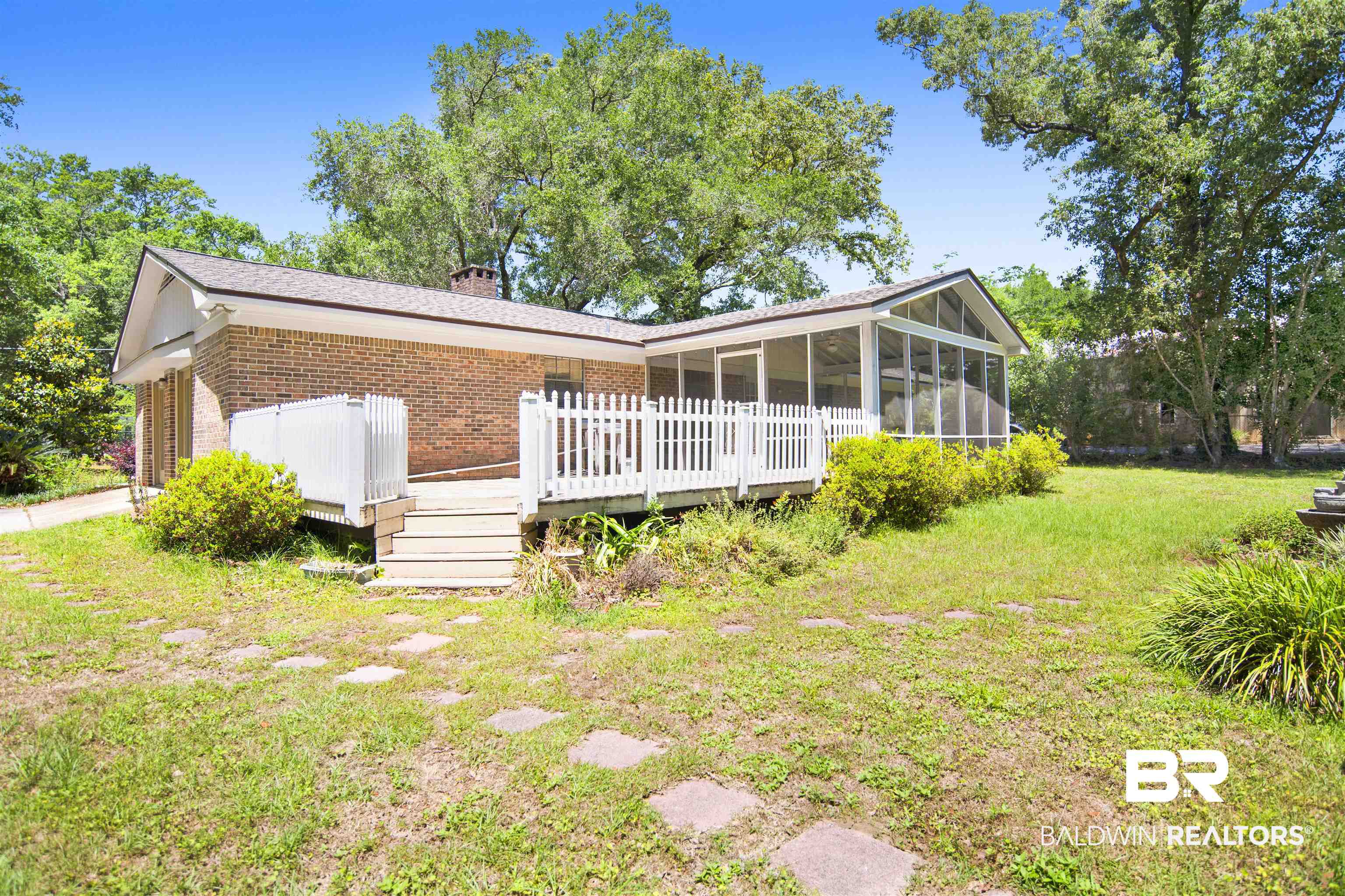 30888 Cemetery Road Daphne, AL 36527 - Photo 29 of 36 Brick exterior featuring a wood deck with white picket railing, a screened porch, and a shingle roof