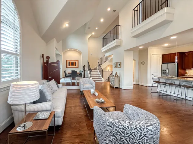 a living room with furniture and a dining table with wooden floor