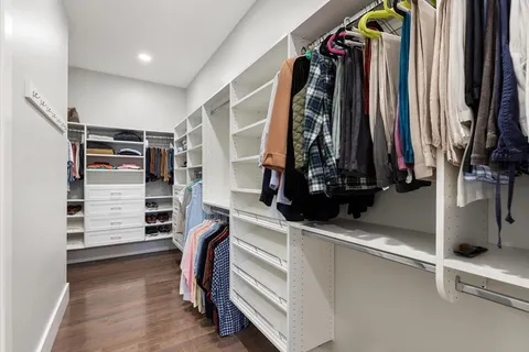 a view of walk in closet with clothes and shoes