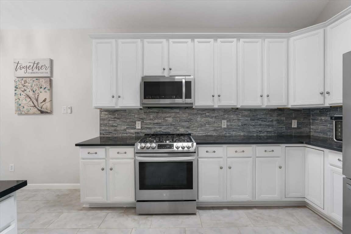 17028 Tortoise Street Round Rock, TX 78664 - Photo 10 of 30 a kitchen with white cabinets and stainless steel appliances