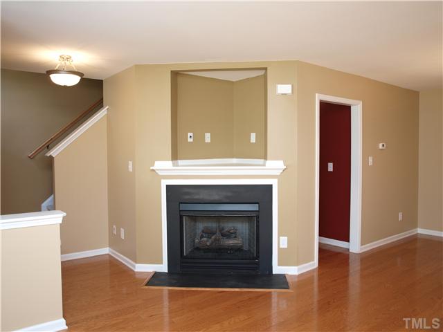 9906 Layla Avenue Raleigh, NC 27617 - Photo 4 of 12 a living room with a fireplace and wooden floor
