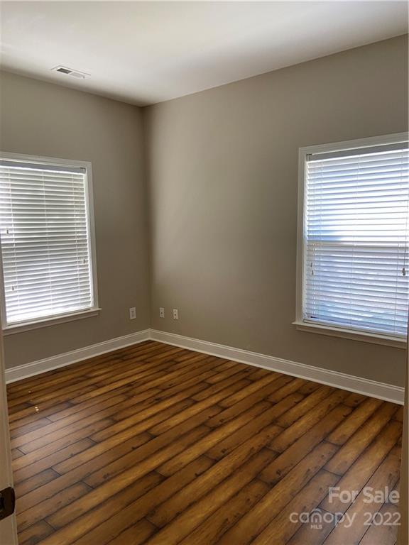 6734 Evanton Loch Road Charlotte, NC 28278 - Photo 20 of 34 a view of an empty room with wooden floor and a window