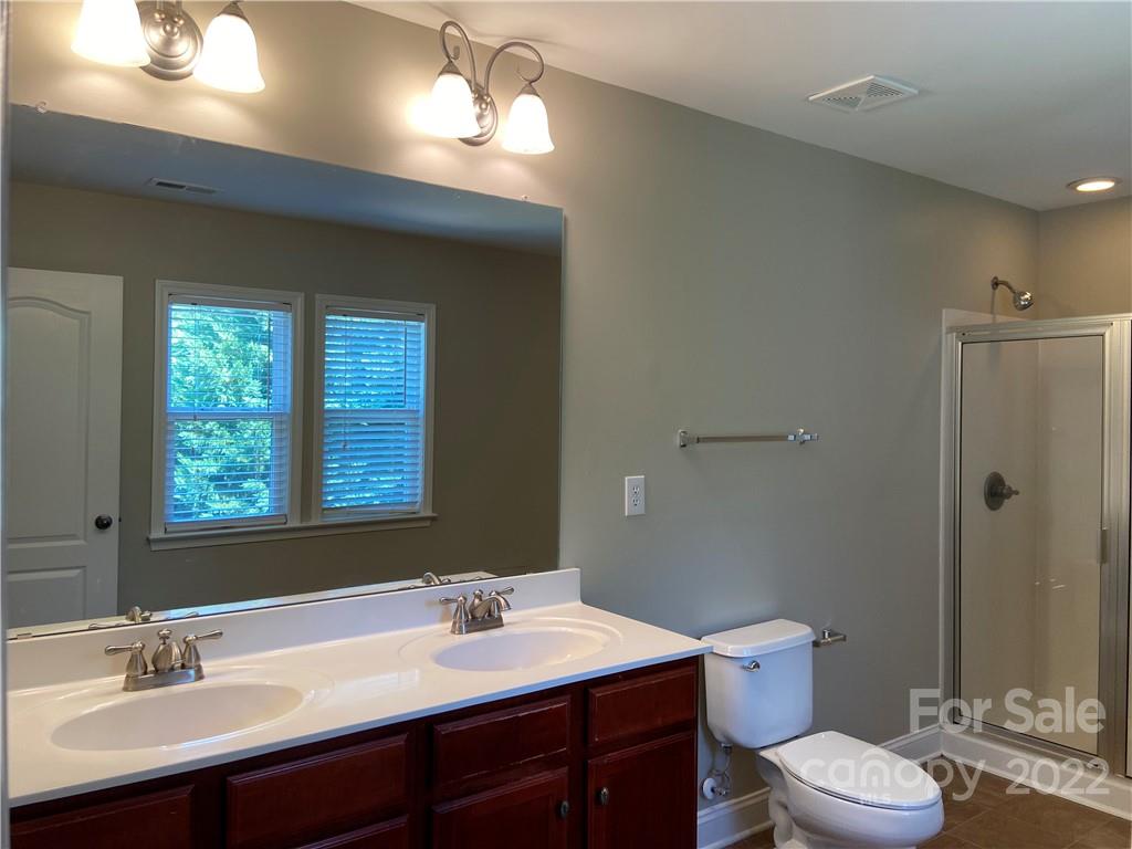 6734 Evanton Loch Road Charlotte, NC 28278 - Photo 27 of 34 a bathroom with a sink a toilet a mirror and a window