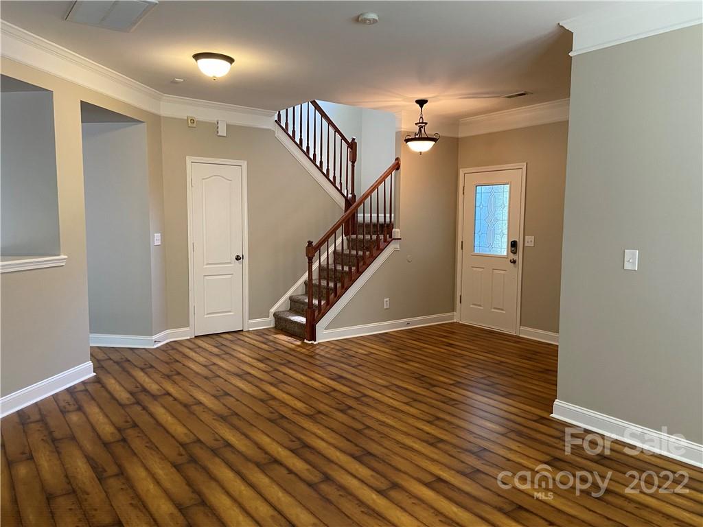 6734 Evanton Loch Road Charlotte, NC 28278 - Photo 8 of 34 a view of an empty room with wooden floor and stairs