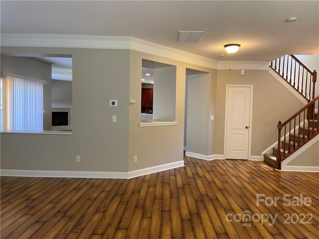 6734 Evanton Loch Road Charlotte, NC 28278 - Photo 10 of 34 a view of an empty room with wooden floor and a window