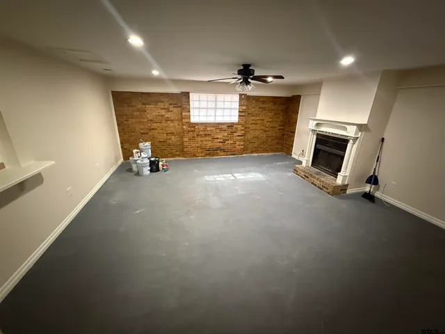 an empty room with windows and fireplace