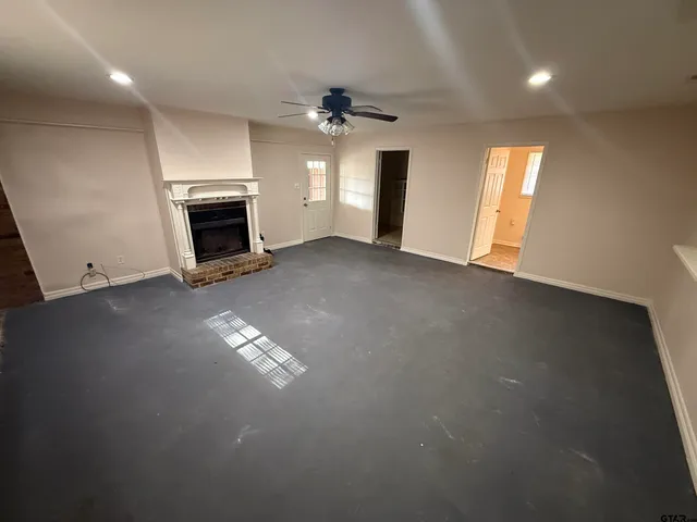 a view of an empty room with a fireplace and a window