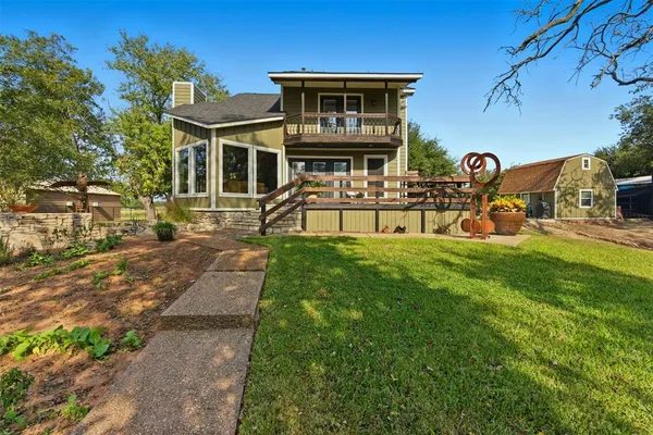 a front view of a house with garden and sitting area