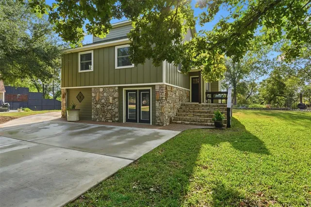 a view of a house with backyard and a tree
