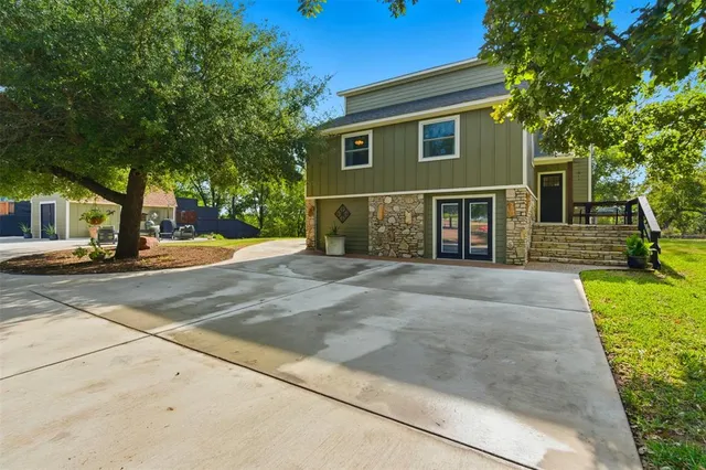 a front view of a house with a yard and trees
