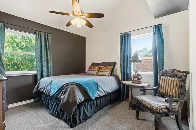 a bedroom with a bed chairs and a window