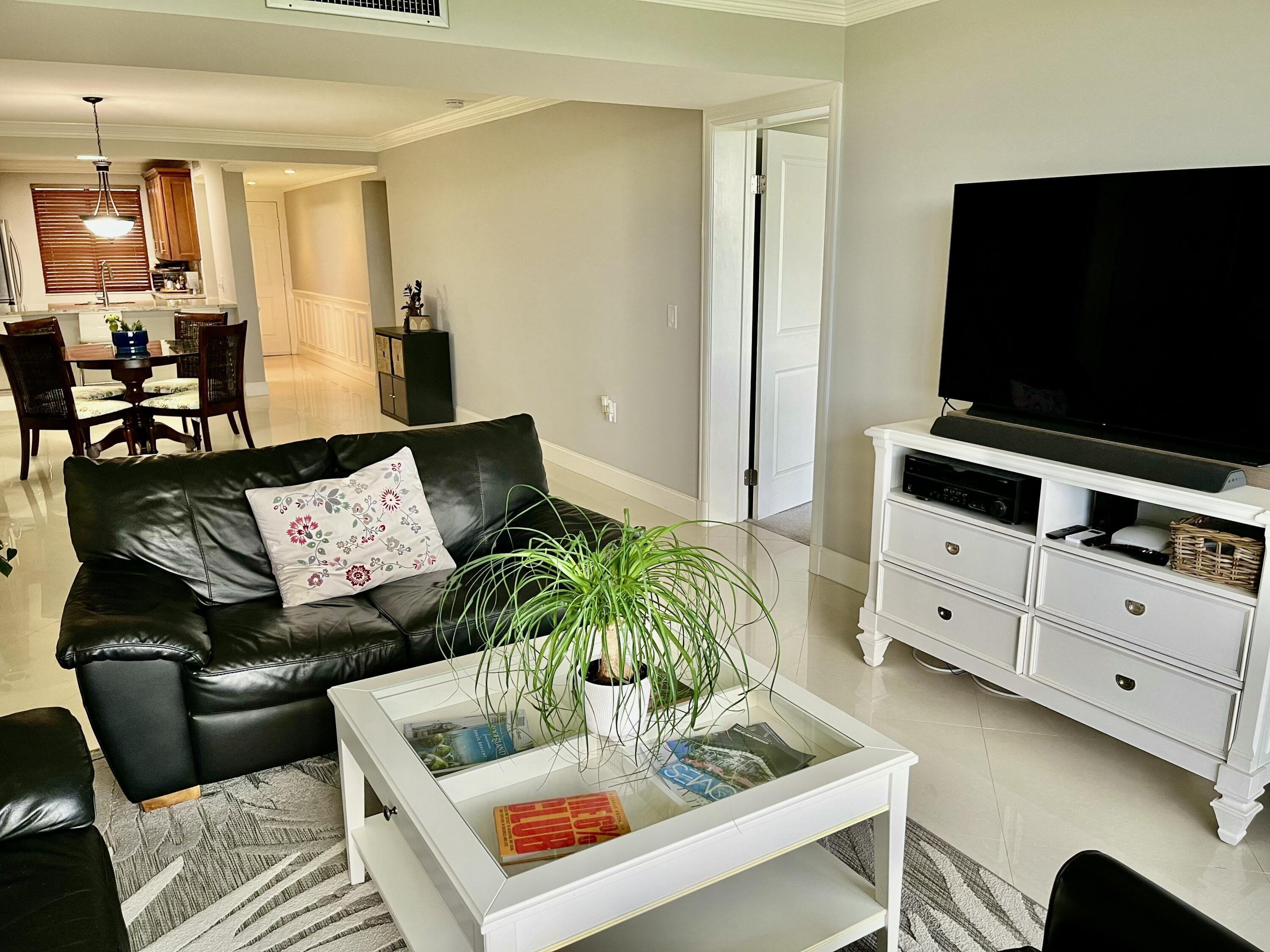 6169 Balboa Circle, Unit 401 Boca Raton, FL 33433 - Photo 13 of 34 a living room with furniture and a flat screen tv
