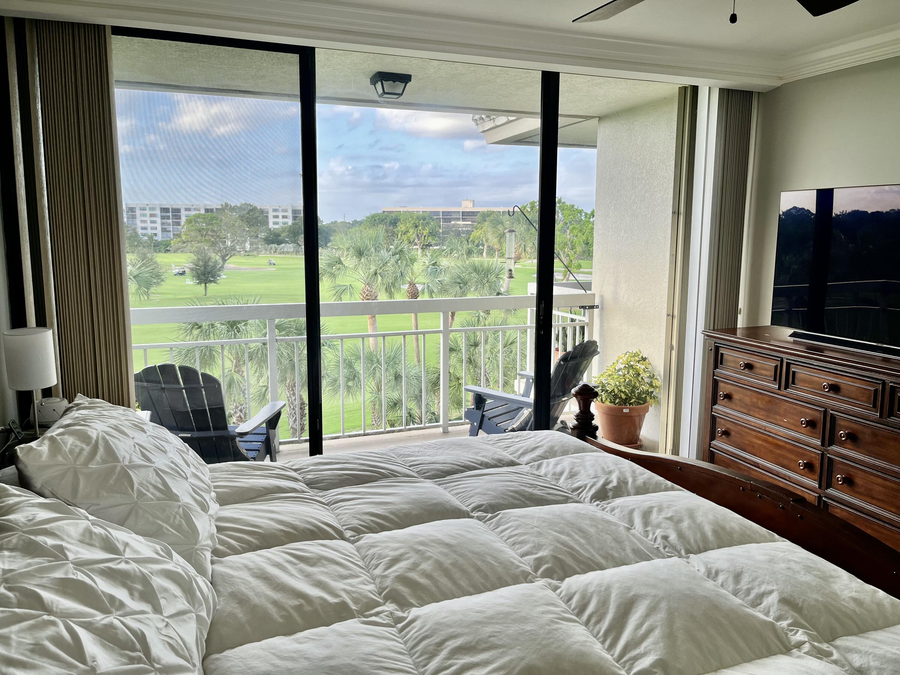 6169 Balboa Circle, Unit 401 Boca Raton, FL 33433 - Photo 17 of 34 a bedroom with a bed and large windows