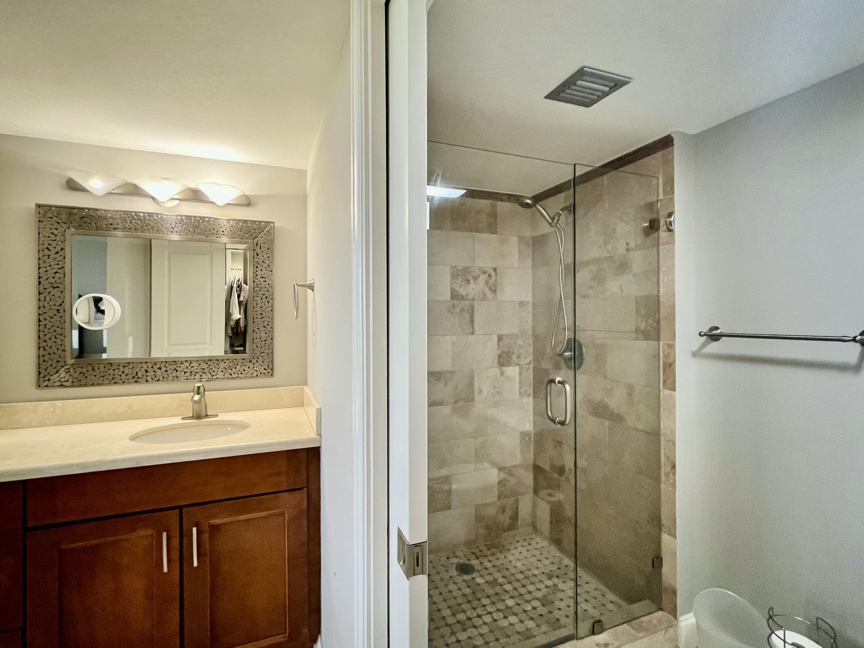 6169 Balboa Circle, Unit 401 Boca Raton, FL 33433 - Photo 19 of 34 a bathroom with a shower sink and mirror