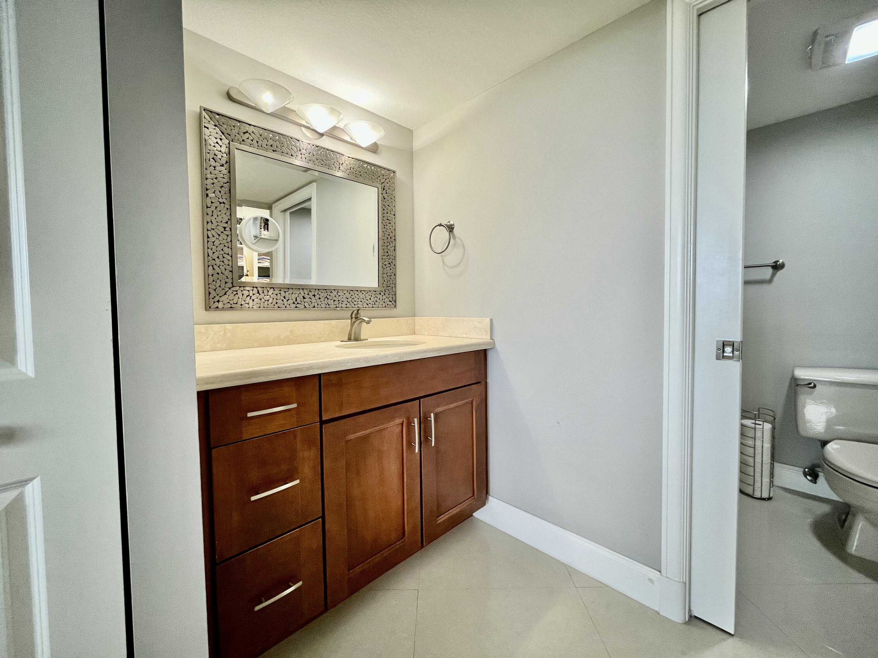 6169 Balboa Circle, Unit 401 Boca Raton, FL 33433 - Photo 20 of 34 a bathroom with a sink vanity and a mirror