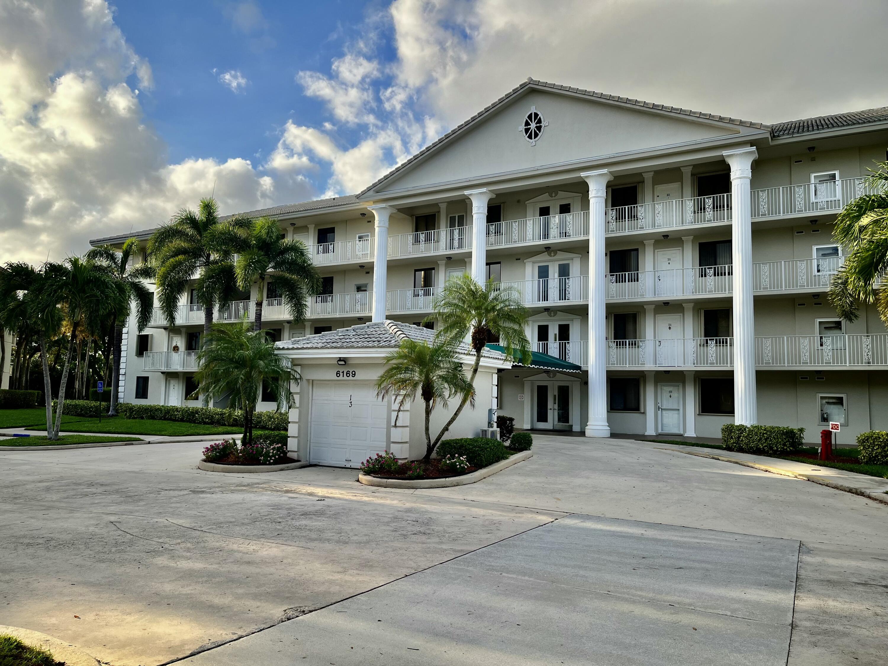 6169 Balboa Circle, Unit 401 Boca Raton, FL 33433 - Photo 2 of 34 a front view of a building with a garden