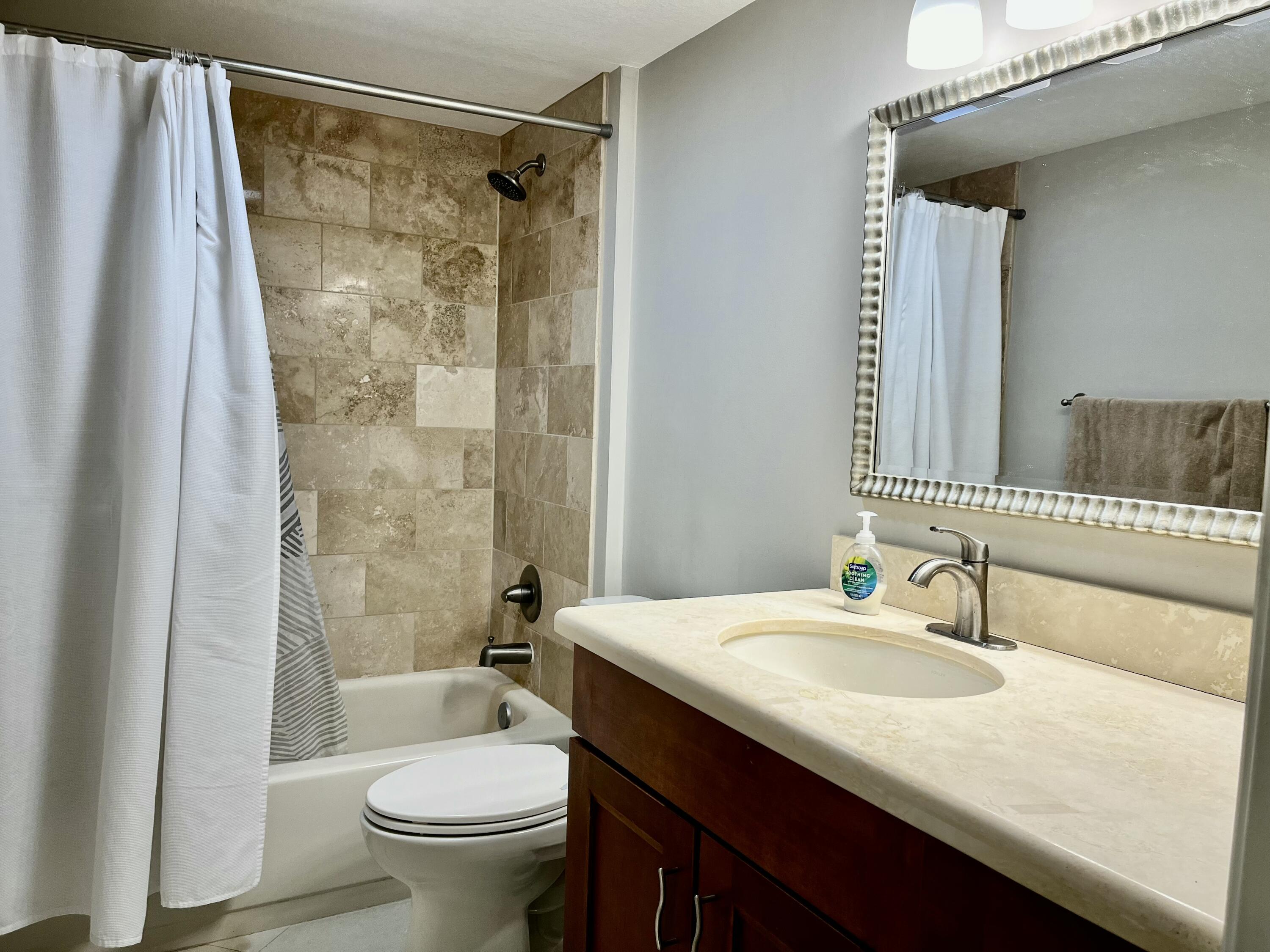 6169 Balboa Circle, Unit 401 Boca Raton, FL 33433 - Photo 26 of 34 a bathroom with a granite countertop sink toilet and shower