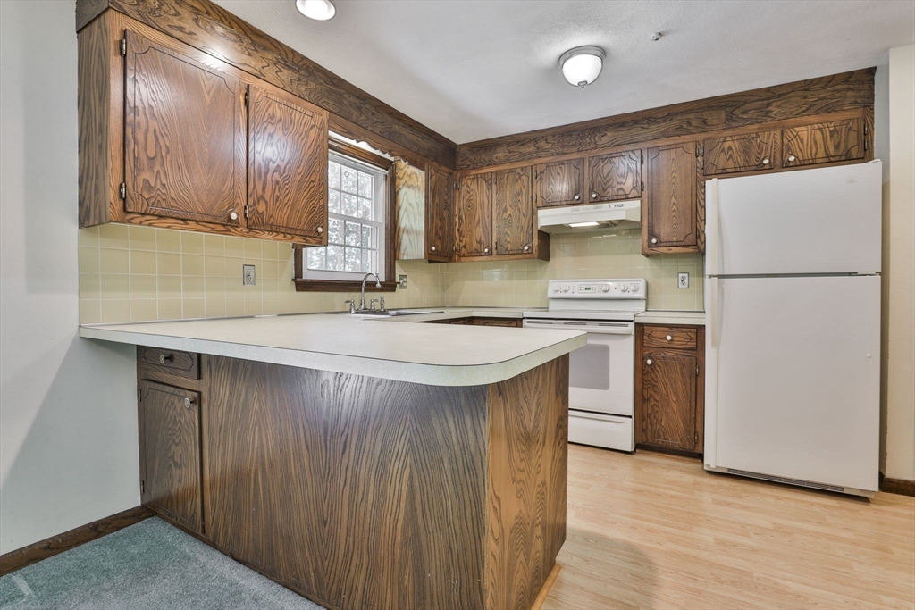 101 Drummer Road, Unit 101 Acton, MA 01720 - Photo 12 of 31 a kitchen with a sink a refrigerator and a stove