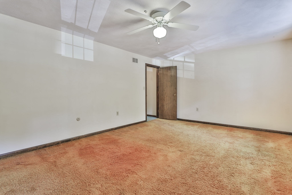 101 Drummer Road, Unit 101 Acton, MA 01720 - Photo 19 of 31 an empty room with a ceiling fan and a window