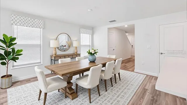 a view of a dining room with furniture and a potted plant